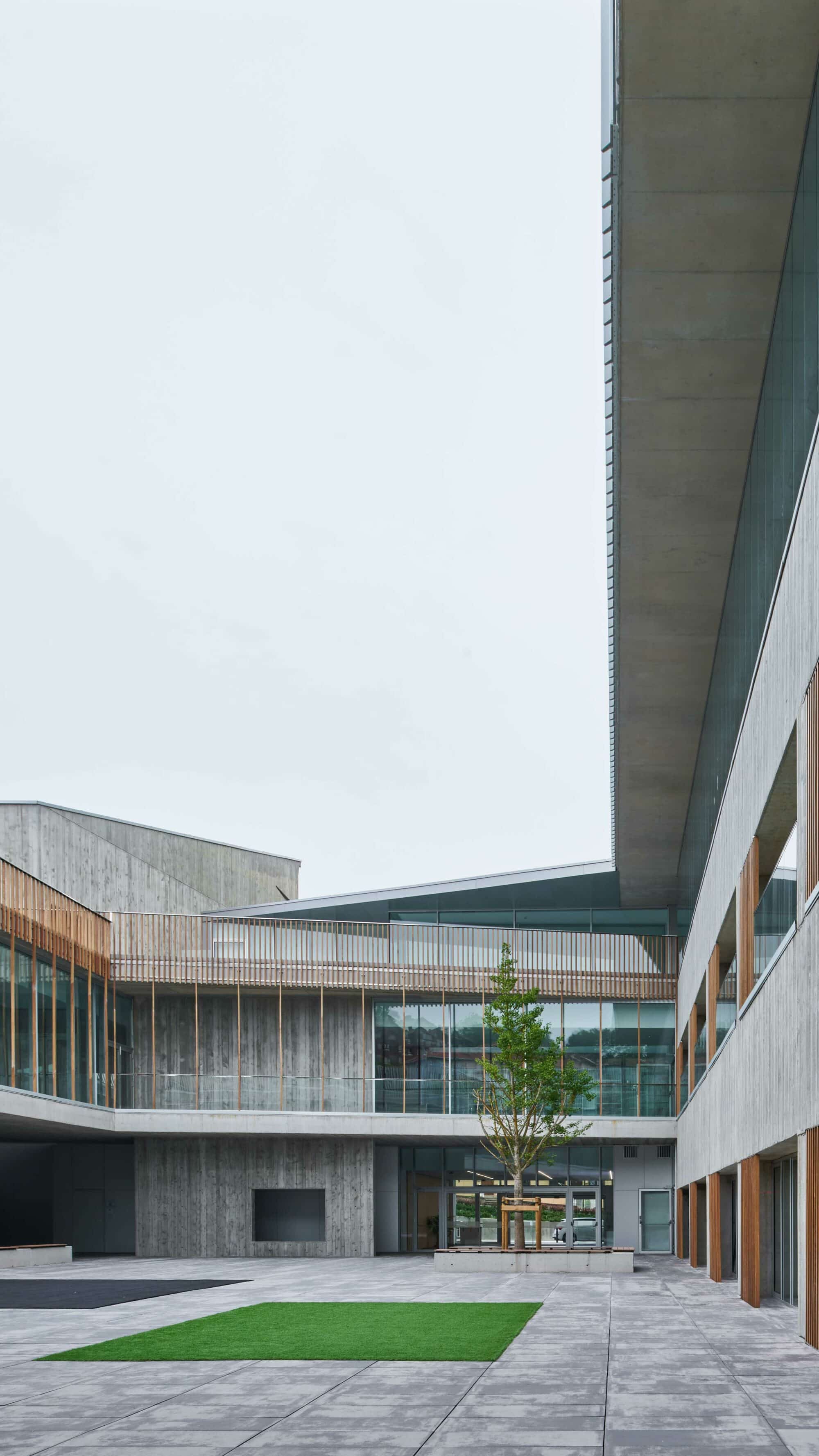 Die vertikale Anordnung der Latten betont den visuellen Rhythmus zwischen Beton und Holz.