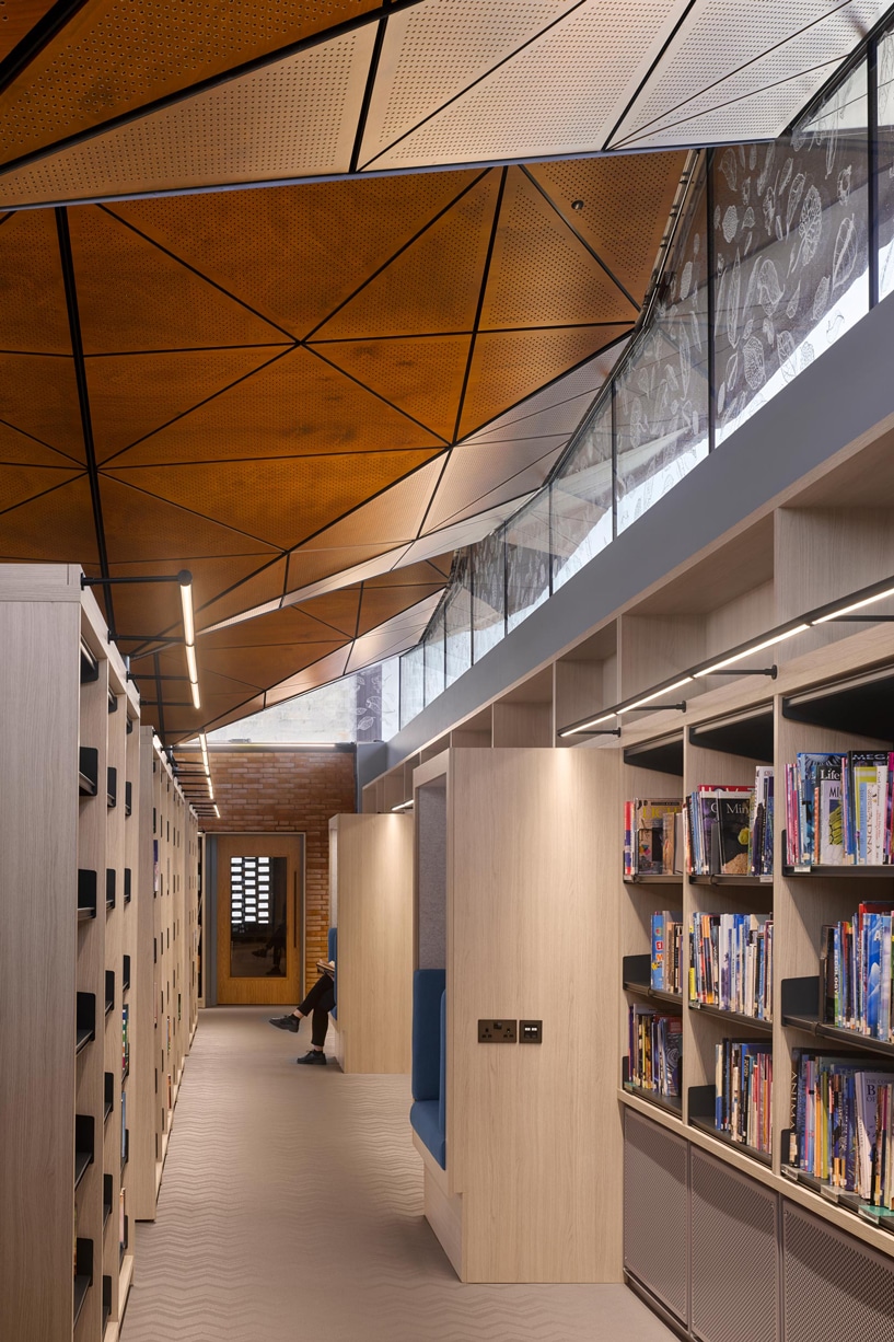 The soffit panels were custom manufactured for this project, including perforations for acoustic purposes, allowing sound to pass through the panel to be absorbed by the insulation behind it.