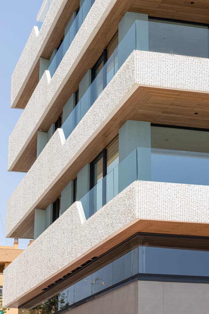 El edificio de apartamentos frente al mar Mediterráneo 176, en Málaga, utiliza techo falso exterior de madera natural Parklex Prodema en los balcones.